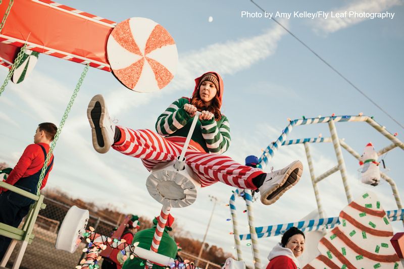 Woman in Christmas outfit on seesaw at Christmas event