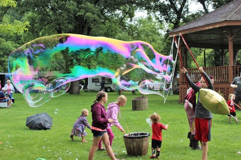Children playing at the bubble station in Lanesboro's Sylvan Park during Buffalo Bill Days