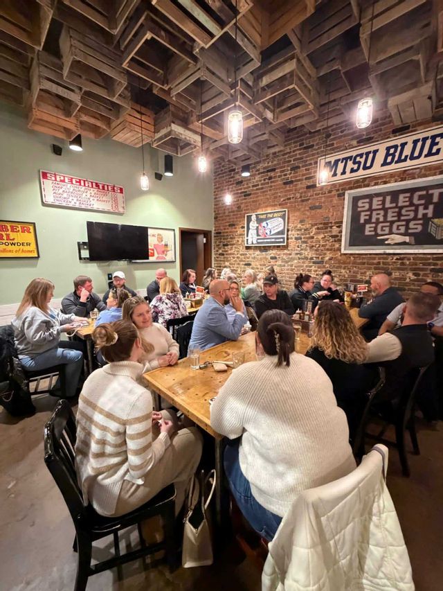 People sitting at tables at Biscuits and Business networking event at Pucketts