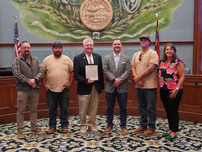 Statesville Public Power representatives stand with Mayor Doug Hendrix inside Statesville City Hall in recognition of the utility receiving ElectriCities of North Carolina’s 2025 Public Power Awards of Excellence in all five award categories. Pictured from left are Ron Smith, Jared Wiles, Jeremiah Christopher, Mayor Doug Hendrix holding the recognition, Cody Leis, Casey Liles, Paul Hauser, and Shannon Viera.