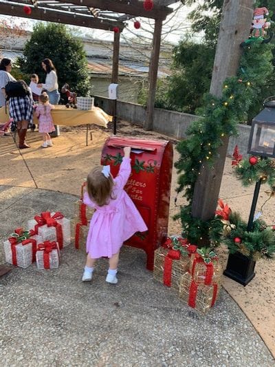 Little girl dropping in her letter to Santa at Christmas event in Bowdon
