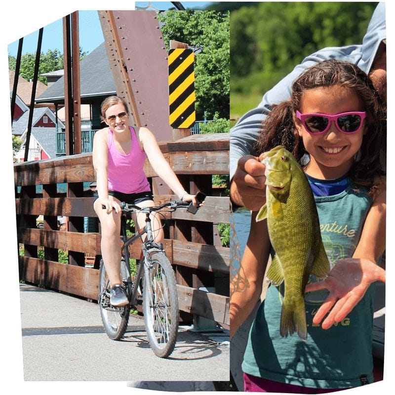 Adult bicyclist riding across a bridge in Lanesboro alongside a child proudly holding a freshly caught fish, showcasing family-friendly outdoor adventure.