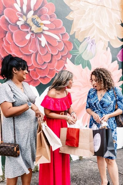 Ladies shopping in front of flower mural downtown