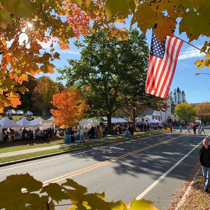 Ashfield Fall Festival with American flag in the foreground