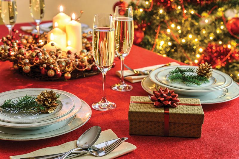 Stock image of Christmas table setting. Festive plates, champagne, and the Christmas tree