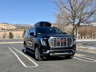 Blue Sky Limo GMC Yukon XL with rooftop cargo box near Eagle County Airport