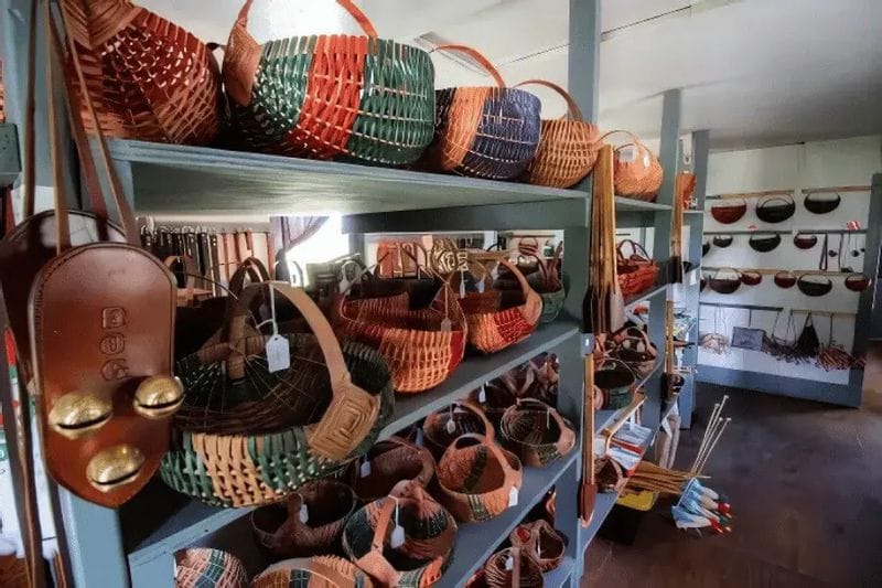 Handwoven baskets and leather goods displayed on shelves inside an Amish craft shop.