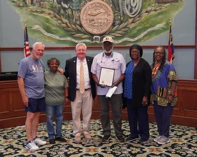Community members stand with Statesville Mayor Doug Hendrix in the City Council Chambers during the June 15, 2026, Statesville City Council meeting. One community representative holds the official proclamation recognizing June 19 as Juneteenth, commemorating the end of slavery in the United States and honoring the history, culture, and contributions of African Americans. The group poses beneath the City of Statesville seal following the proclamation presentation.