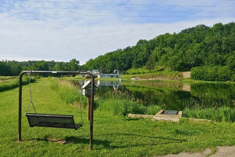 Peaceful view of Bass Pond in Lanesboro, Minnesota, with a swing bench near the water.