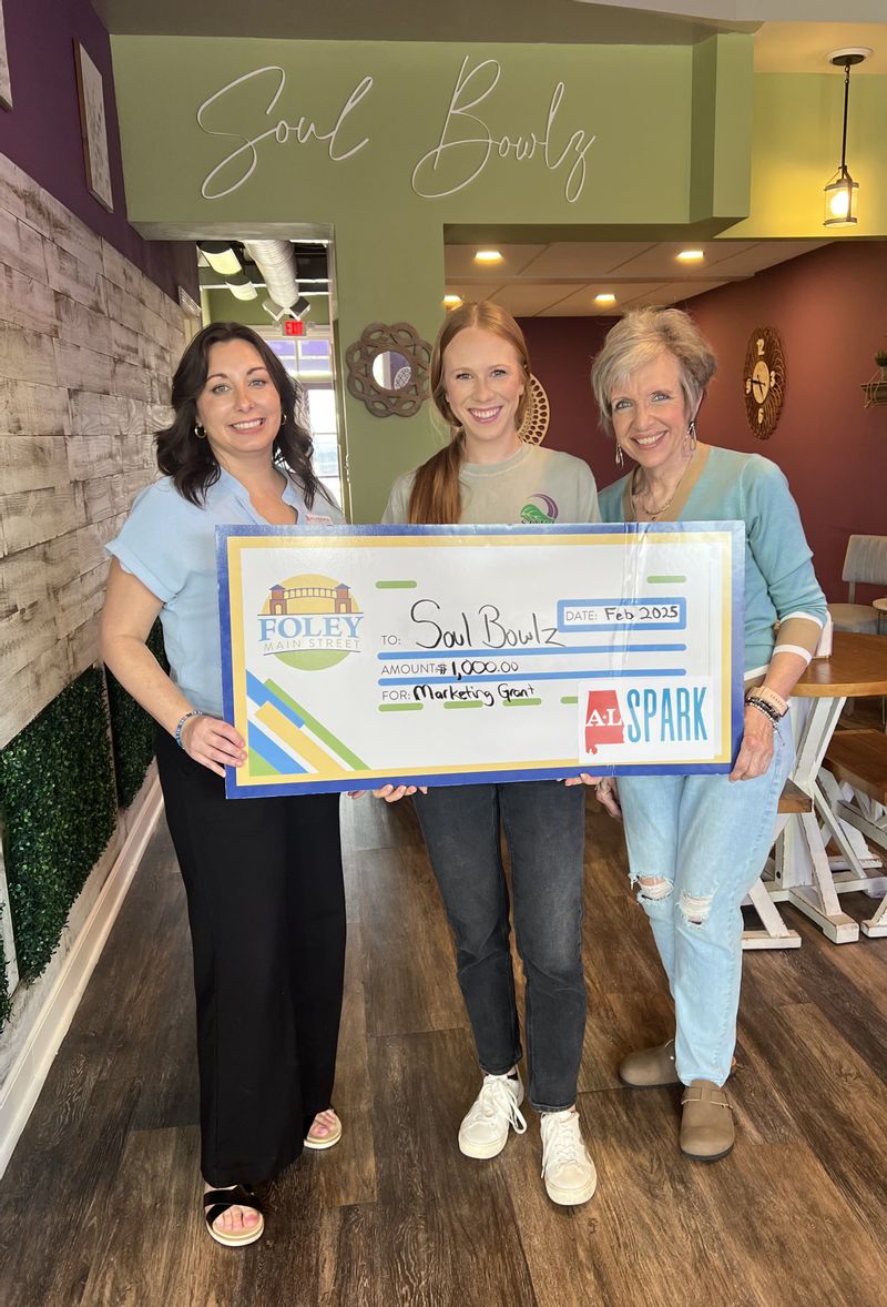 Soul Bowlz - Foley  is a  2025 Winner of a $1,000 marketing grant through ALSPARK. Owner Taylor Hubbard accepted the check. Foley Main Street board members Deborah Mixon and Sabrina May presented the check.