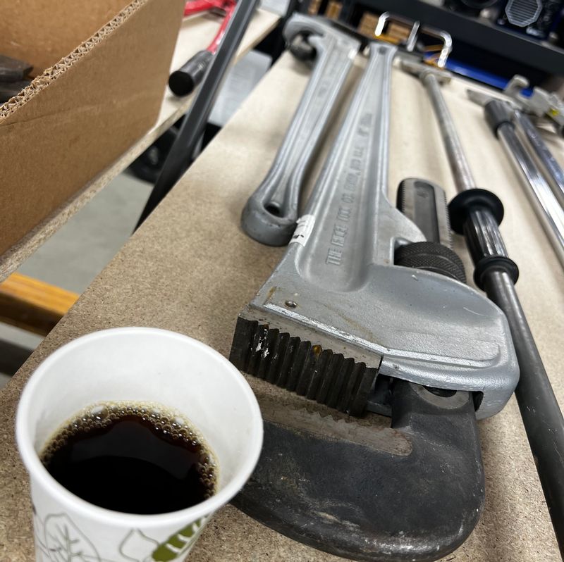 Giant wrenches and a coffee cup for scale