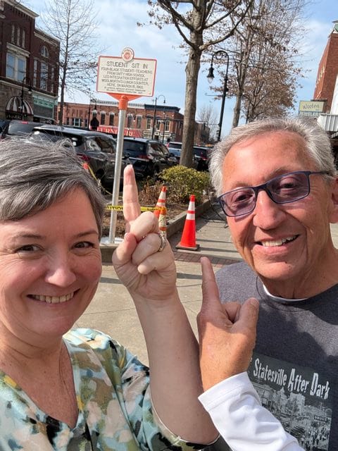 Cindy Sutton and Steve Hill point toward the North Carolina Civil Rights Trail marker commemorating Statesville’s 1960 Woolworth’s lunch counter sit-in.