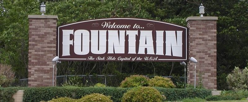 Welcome to Fountain sign with the phrase "The sinkhole capital of the world" printed on the bottom