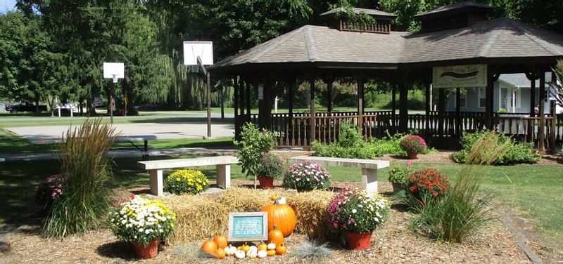 Gazebo, basketball court, and fall-decorated garden with benches in Whalan, MN
