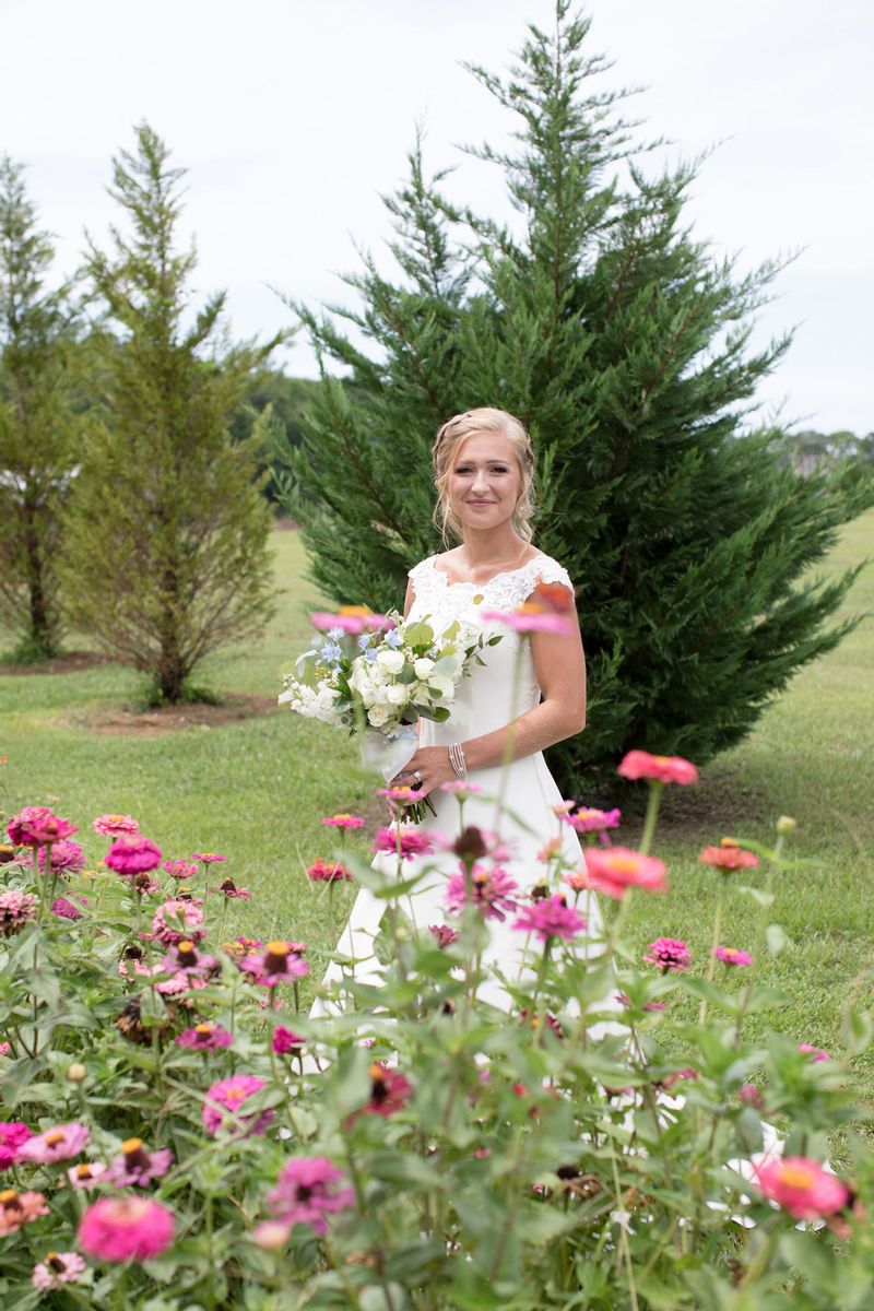 Bride posing with bouquet and wildflower scenery
