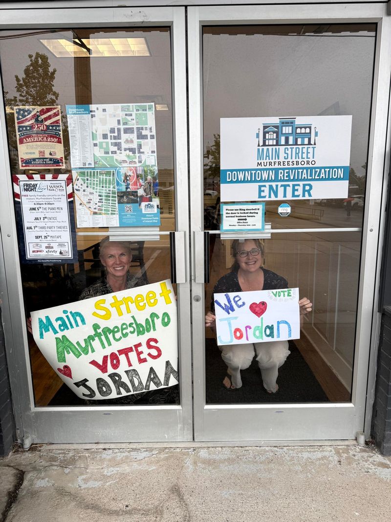 Kathy and Sarah holding vote for Jordan sign inside the Main Street office