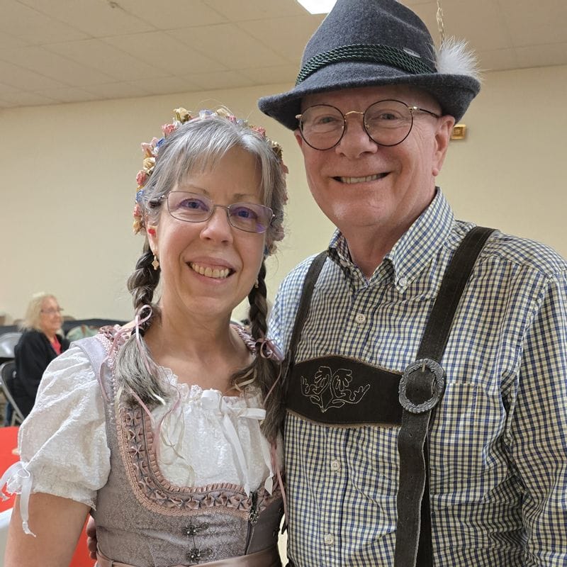 Smiling couple in German costume with lederhosen.