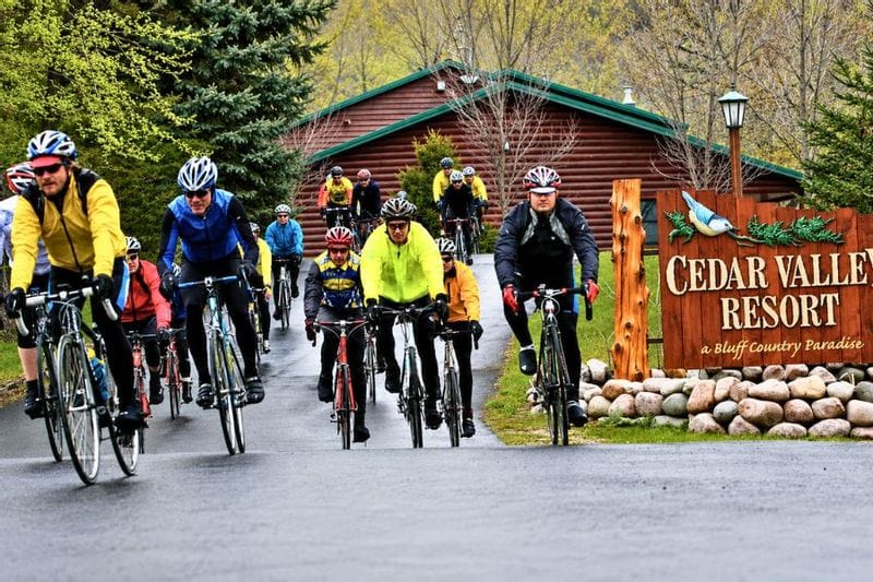 A group of bikers in rain gear embarking on a cycling trip from Cedar Valley Resort in Whalan, MN