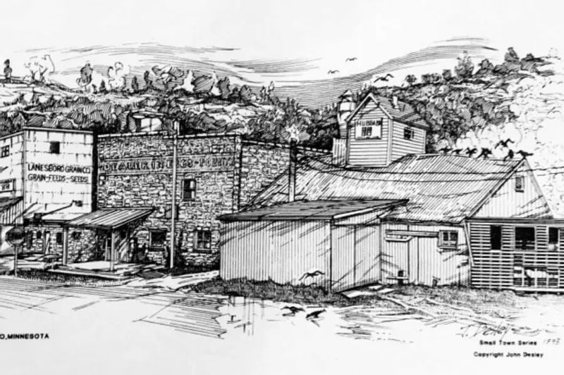 A detailed black-and-white illustration depicts the historic Stone Mill and Feed Mill buildings in Lanesboro, showing early industrial structures set against rolling bluffs and the surrounding river valley landscape.