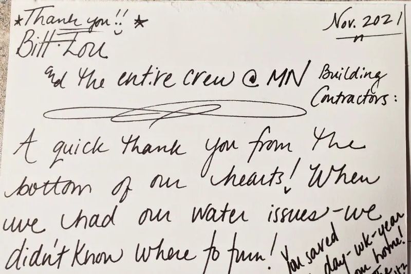 A handwritten thank-you note dated November 2021 expresses gratitude to Bill and the entire crew at Minnesota Building Contractors for their help resolving water issues, written in black ink on white paper.