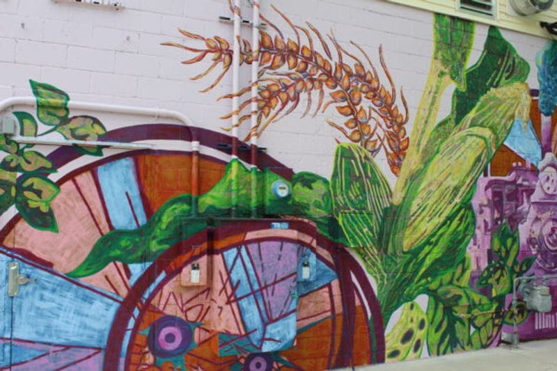 Colorful mural in downtown Lanesboro, Minnesota, featuring agricultural and artistic imagery painted on the side of a building as part of the community’s public art scene in Bluff Country