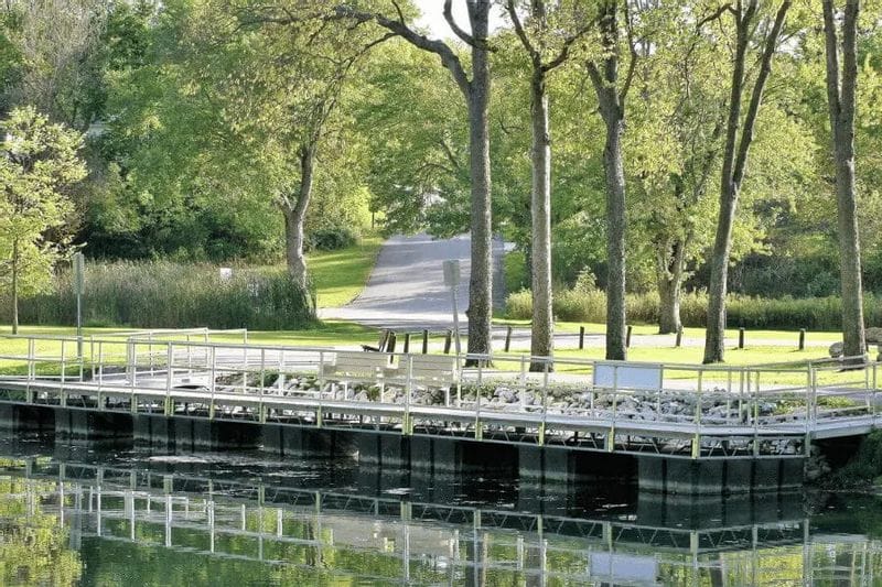 A dock along the pond at Sylvan Park in Lanesboro, Minnesota, surrounded by trees and green space.