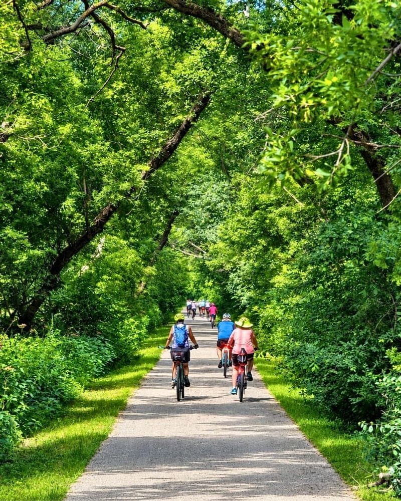 Bikers riding the Root River State Trail near Lanesboro, MN through lush green foliage