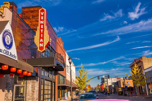  A beautiful day on Main Street downtown displaying several buildings.  On the left there is an iconic bold red and gold Venetian sign