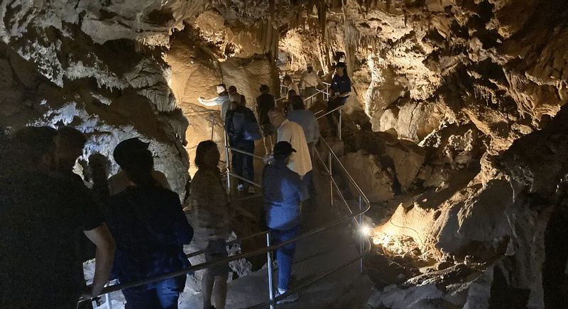 Visitors walk along a lighted pathway inside Niagara Cave, exploring dramatic rock formations and underground passages on a guided cave tour near Lanesboro, Minnesota.