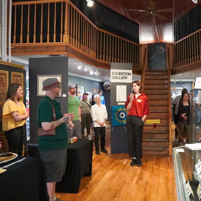 Artist speaking at a Lanesboro Arts gallery opening in the Exhibition Gallery during an evening community event