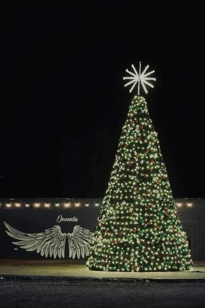 Christmas tree display with wing mural in Oneonta