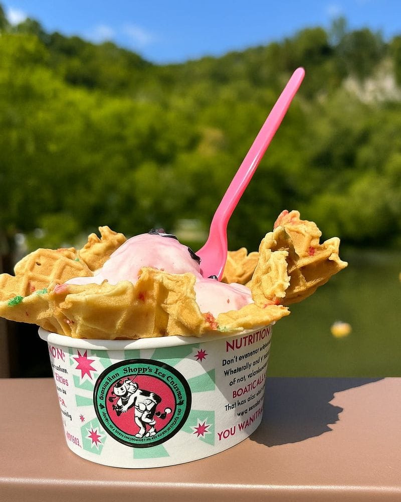 A cup of ice cream topped with waffle pieces and a pink spoon from Clara’s Eatery in Lanesboro, Minnesota.