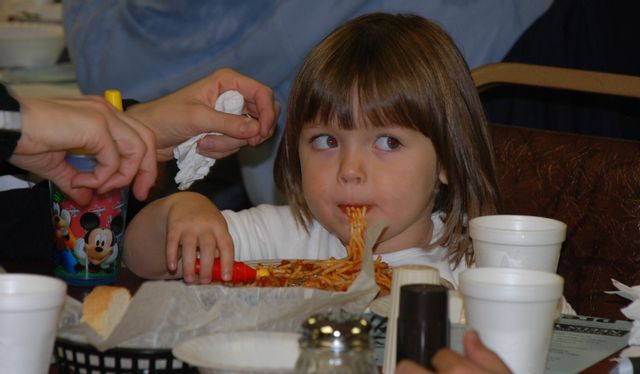 young girl eating spaghetti