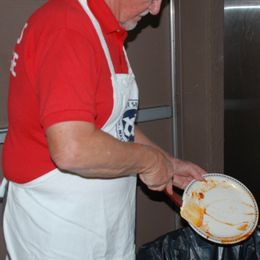 Exchange club member in red shirt cleans plate